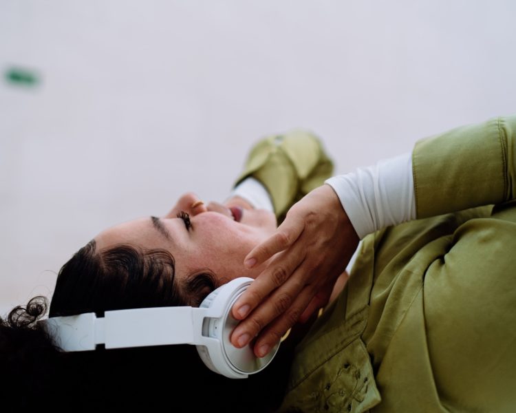 Woman,Lying,Down,,Absorbed,In,Enriching,Audio,Experience,Through,Advanced